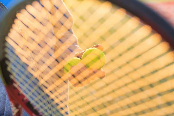 Uomo maturo che tiene le palle da tennis contro la racchetta — Foto Stock