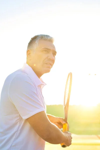 一个成熟的人在阳光灿烂的日子打网球 — 图库照片