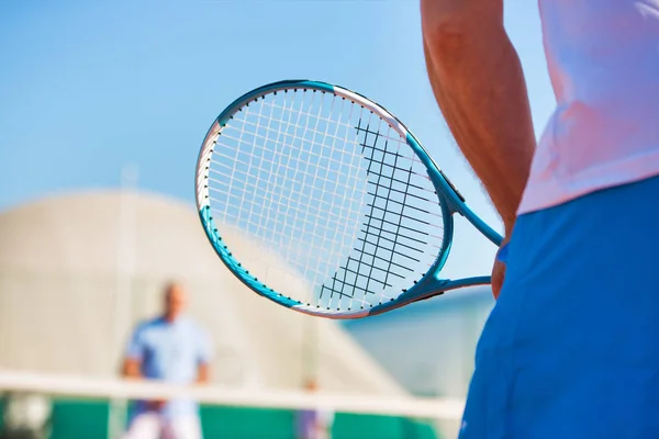 Photo of mature man holding tennis racket against friend playing — Stock Photo, Image