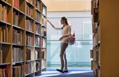 Öğrenci Üniversitesi Kütüphanesi'nde kitap seçimi