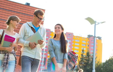 Üniversite kampüsünün dışında yürüyen öğrenciler