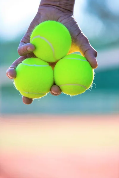 Фото пожилого человека, держащего теннисные мячи на корте — стоковое фото