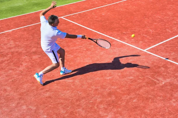 Selbstbewusster älterer Mann spielt an sonnigem Tag Tennis — Stockfoto