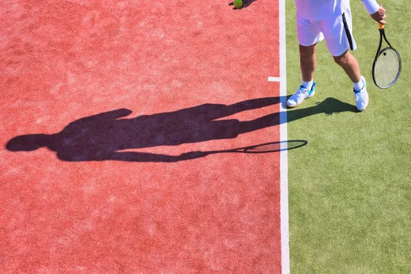 Självsäker mogen man spelar tennis på solig dag — Stockfoto