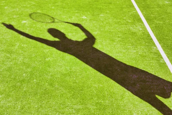 网球运动员在草地球场击球的阴影 — 图库照片
