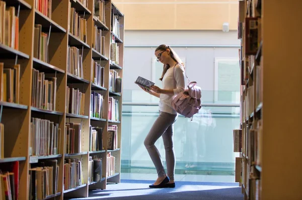 Livro de leitura de estudantes na biblioteca universitária — Fotografia de Stock