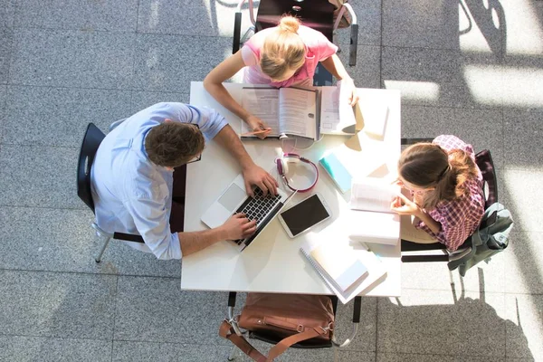 Students doing group projects while sitting on table at universi — Stock Photo, Image