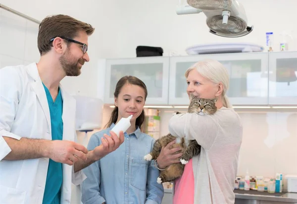 Arts geeft advies en geneeskunde aan kattenbezitter in kliniek — Stockfoto