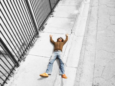 Ölü kurban kaldırımda uzanmış, manzara yükselmiş.