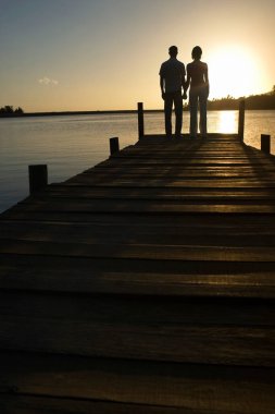 Göl kenarında el ele tutuşan bir çift..