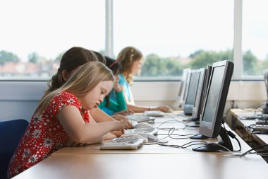 Bilgisayar laboratuvarında bilgisayar kullanan çocuklar (10-12)