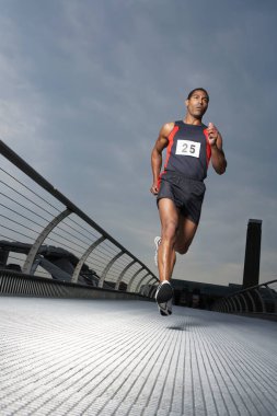 Footbridge 'de koşan sporcu Millennium Köprüsü Londra İngiltere