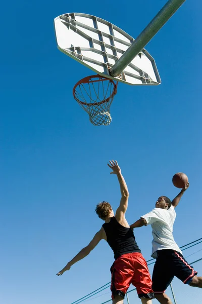 Basketbolcu Basketbolu Alçaktan Vurmaya Çalışırken Diğerini Koruyor — Stok fotoğraf