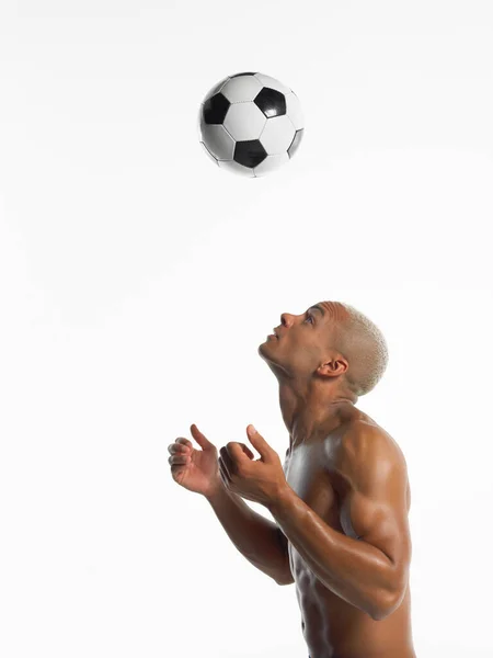 足球运动员在半空中看着球 — 图库照片