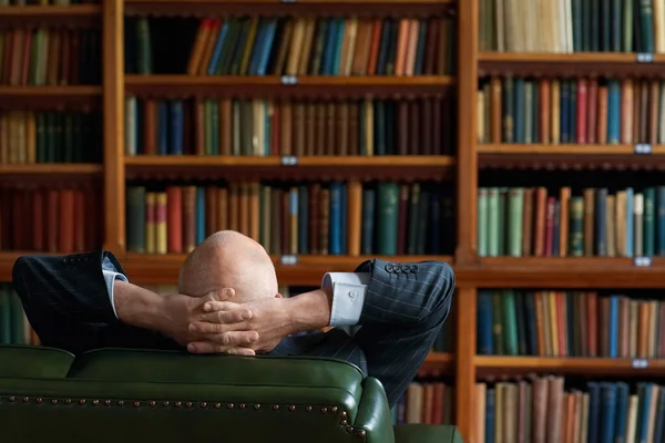 Adamı Kütüphanede Oturuyor Ellerini Başının Arkasına Koyuyor — Stok fotoğraf