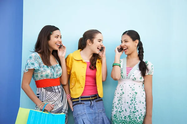 Tres Adolescentes Usando Teléfonos Móviles Pie Frente Pared Azul —  Fotos de Stock
