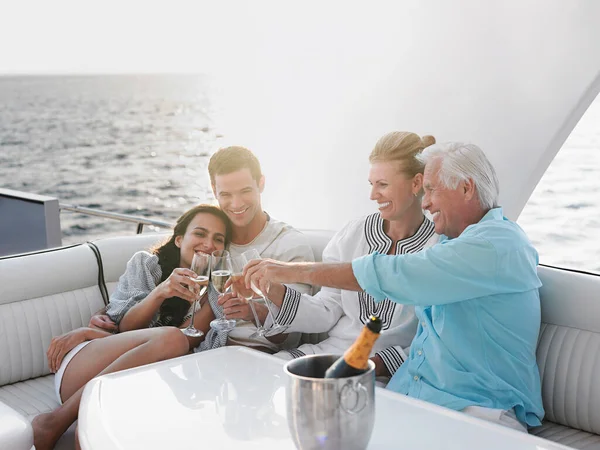 两代人在游艇上喝香槟庆祝 — 图库照片