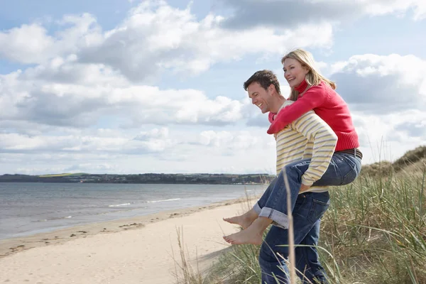 Mannen Ger Kvinnan Gris Tillbaka Stranden — Stockfoto