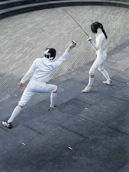 Two athletes fencing on steps of the Scoop amphitheatre London England elevated view