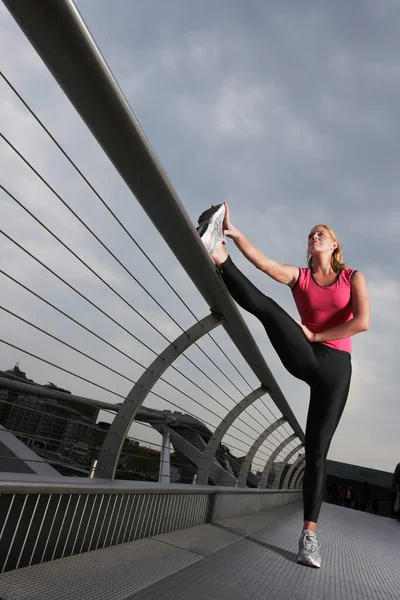 女子在步行桥上伸展低角度俯瞰千禧桥英国伦敦 — 图库照片