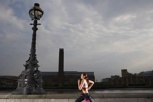 三项全能运动员沿着河堤跑步伦敦英国侧景 — 图库照片