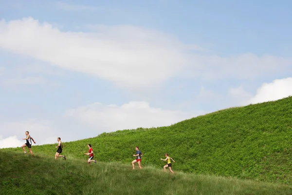 グループの丘の中腹にジョギング — ストック写真