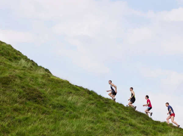丘の中腹を走るグループ — ストック写真