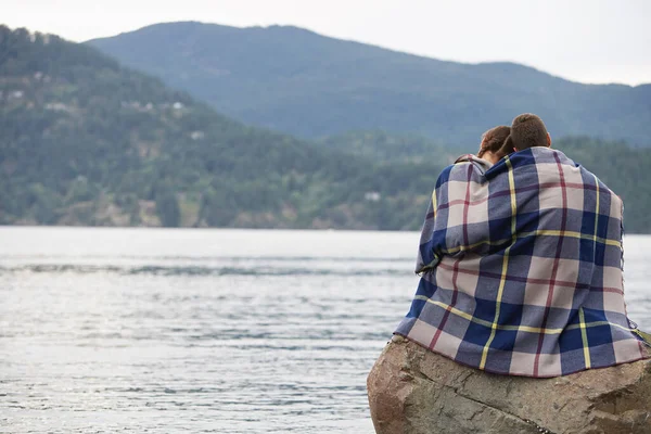 Paar Decke Gehüllt Auf Felsen Meer Sitzend — Stockfoto