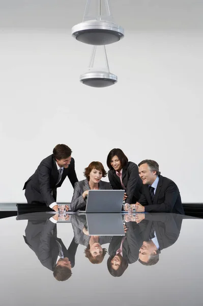 会議台でラップトップを使用している4人のビジネス同僚 — ストック写真