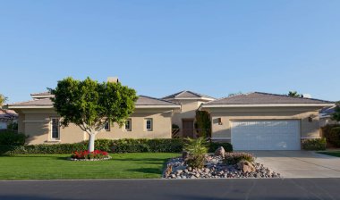 Evin önünde çimenlik ve garaj yolu var.