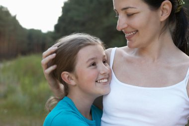 Anne kızını dışarıda kucaklıyor.