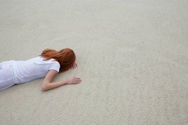 Kumsalda yüzükoyun yatan kadın