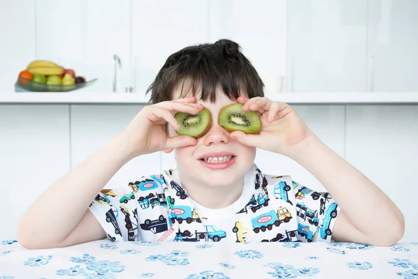 Menino Colocando Fatias Kiwi Nos Olhos — Fotografia de Stock