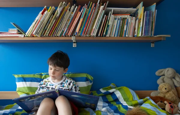 Junge Sitzt Auf Bett Und Liest Buch — Stockfoto