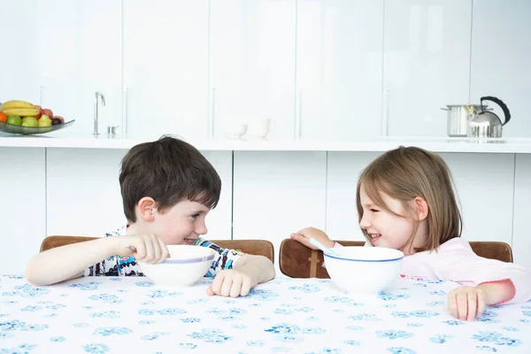 Αγόρι Και Κορίτσι Κάθονται Στο Τραπέζι Τρώγοντας Δημητριακά Και Κοιτώντας — Φωτογραφία Αρχείου