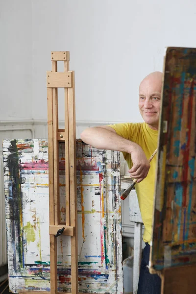 松驰的男性画家 画笔靠在画架上 — 图库照片