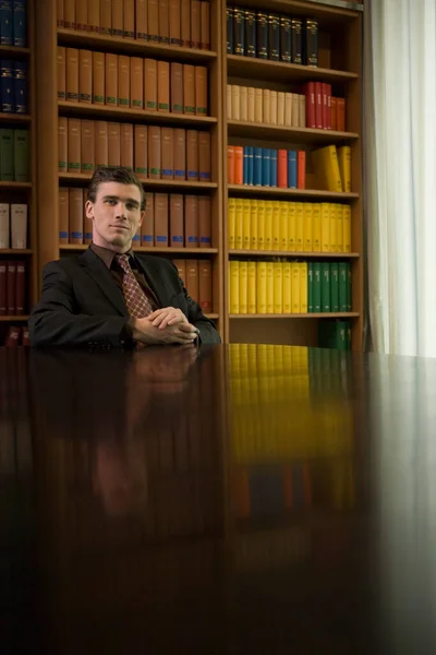 男身に着けているスーツに机で図書館の肖像画 — ストック写真