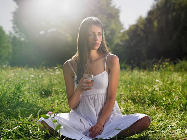 Young Woman Sitting Meadow Cross Legged Holding Drinking Glass — Stock Photo, Image