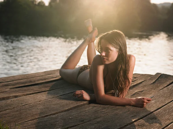 Junge Frau Bikini Liegt Auf Steg Und Schaut Weg — Stockfoto