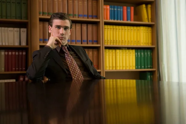 男身に着けているスーツに机で図書館の肖像画 — ストック写真