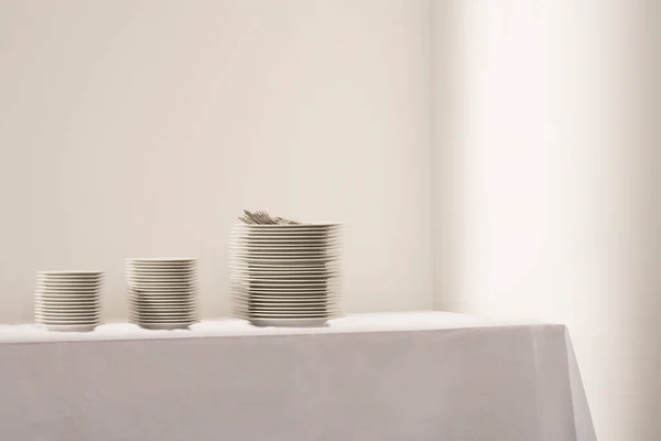 Τρεις Στοίβες Πιάτα Και Μαχαιροπήρουνα Στο Τραπέζι — Φωτογραφία Αρχείου