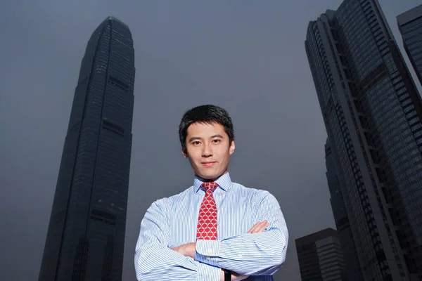 China Hong Kong business man standing in front of International Finance Centre building low angle view portrait