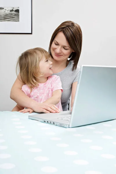 母亲和女儿 坐在笔记本电脑旁边 — 图库照片