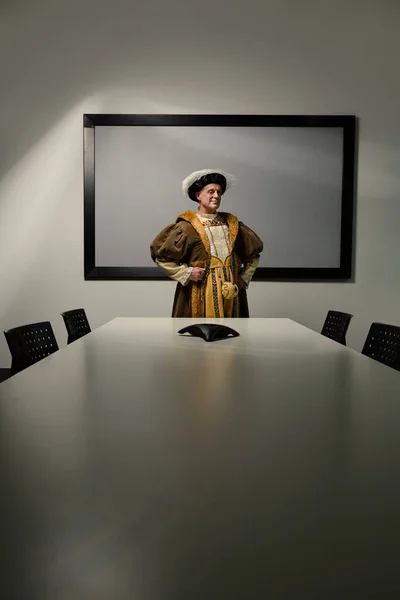 King Henry VIII standing at table in conference room