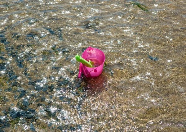 浅い水でおもちゃのバケツとスペード — ストック写真