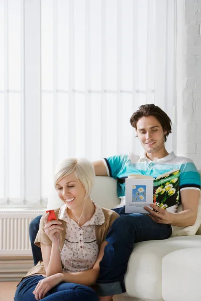 Mujer Joven Escuchando Reproductor Mp3 Lado Del Hombre Leyendo Libro — Foto de Stock