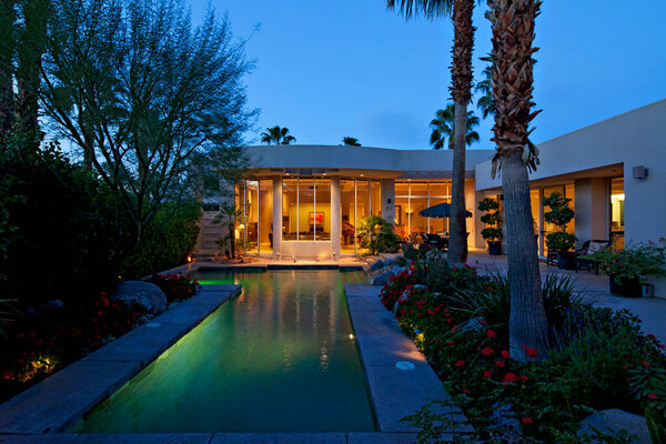 Swimming pool outside mansion at dusk