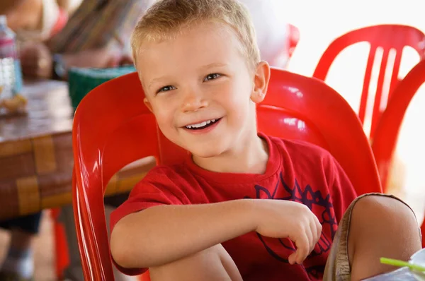 Malý Chlapec Sedí Červeném Plastovém Křesle — Stock fotografie