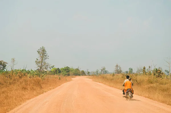 Motocyklista Dający Przejażdżkę Młodemu Monkowi Wiejskich Drogach — Zdjęcie stockowe
