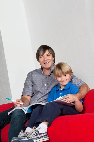 Portrait Father Son Doing Homework Together While Sitting Sofa — Stock Photo, Image